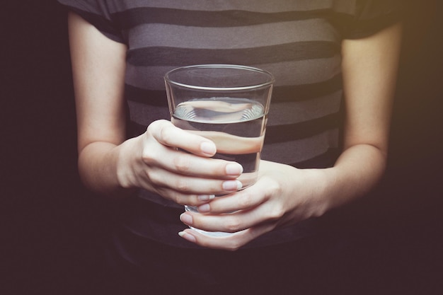 사진 검은 바탕 에 물 한 잔 을 들고 있는 여자 의 중간 부분