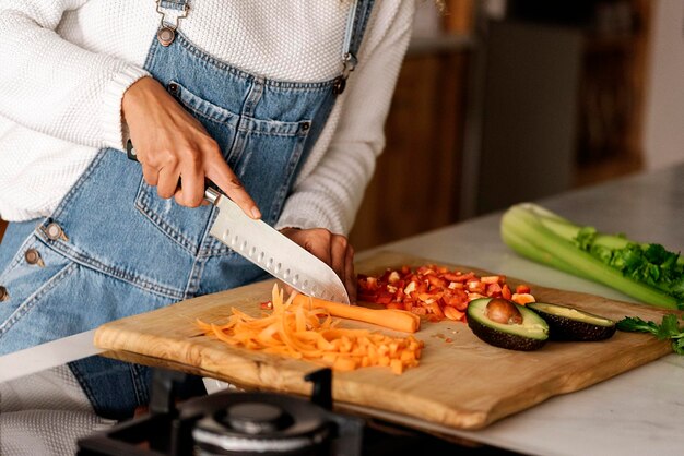 写真 カッティングボードで食べ物を調理している女性のミッドセクション