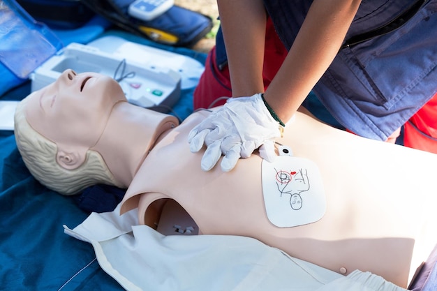 Midsection of paramedic performing cpr on dummy outdoors