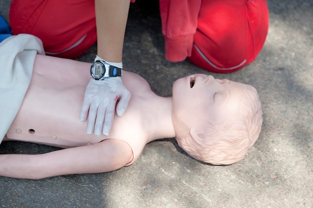 Photo midsection of paramedic performing cpr on dummy