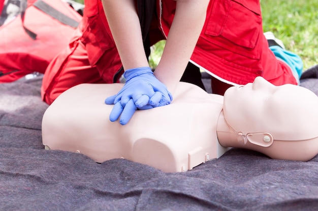 Midsection of paramedic performing cpr on dummy