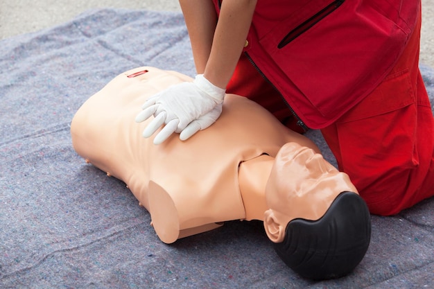 Photo midsection of paramedic performing cpr on mannequin