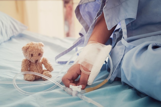 Foto sezione centrale del paziente seduto dall'orso di peluche sul letto dell'ospedale