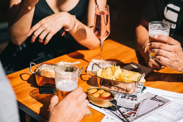 Photo midsection of people holding drink on table