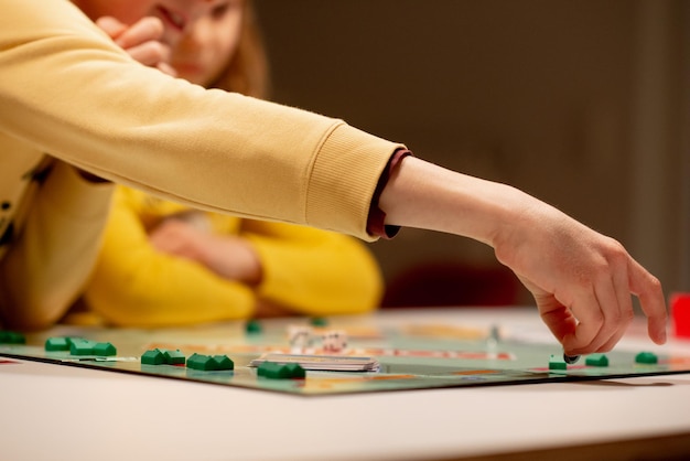 Photo midsection of people playing board game at home