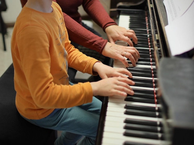 Foto sezione centrale di persone che suonano il pianoforte a casa