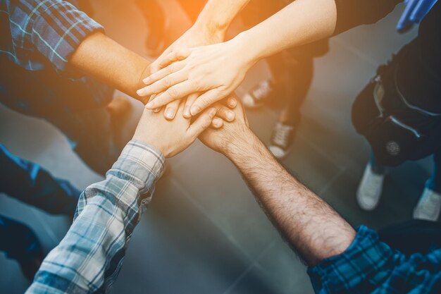 Midsection of people stacking hands