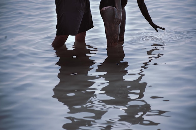 Photo midsection of people standing in water