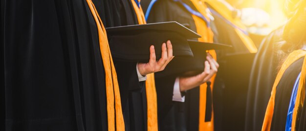 Midsection of people wearing graduation gowns