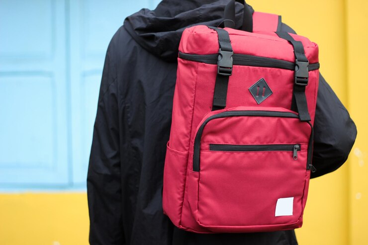 Photo midsection of person carrying red bag against wall