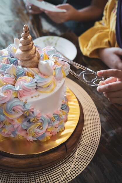 Photo midsection of person cutting a birthday cake on table