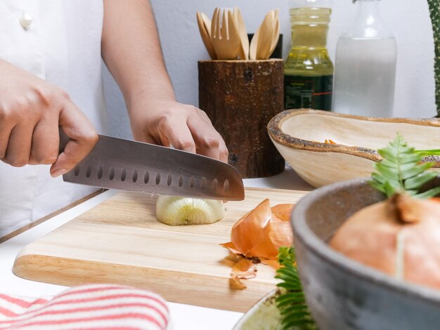 Photo midsection of person cutting onion on table