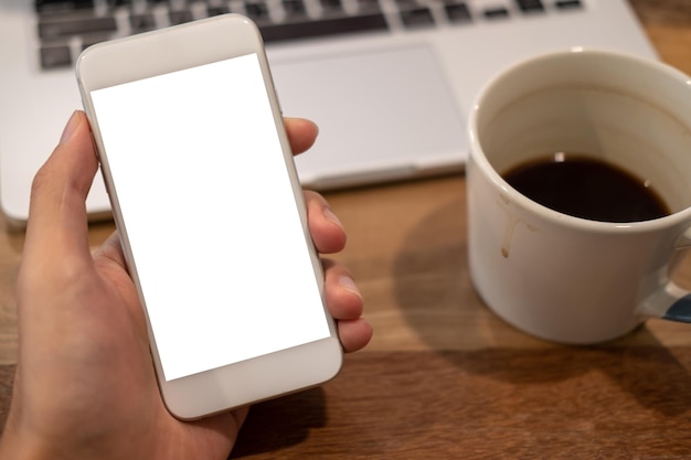Midsection of person holding coffee cup on table