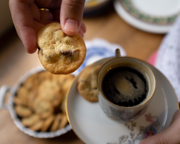 Photo midsection of person holding coffee cup on table