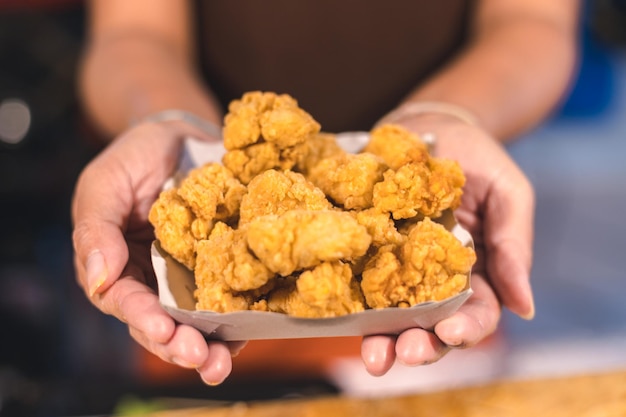 Photo midsection of person holding fried food in box