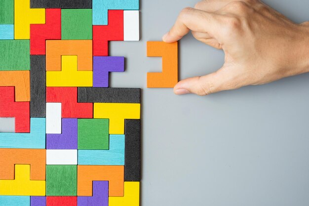 Midsection of person holding multi colored painting on wall