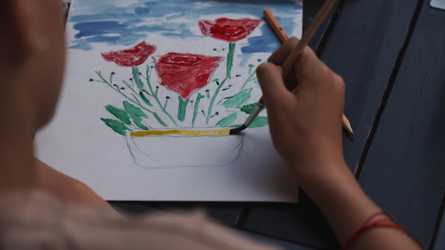 Photo midsection of person holding painting on table