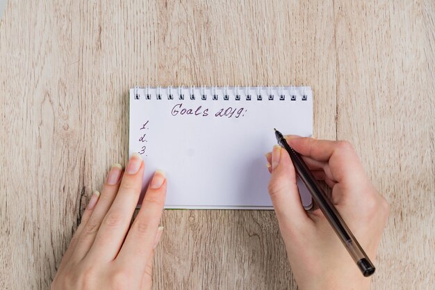 Midsection of person holding paper with text on table