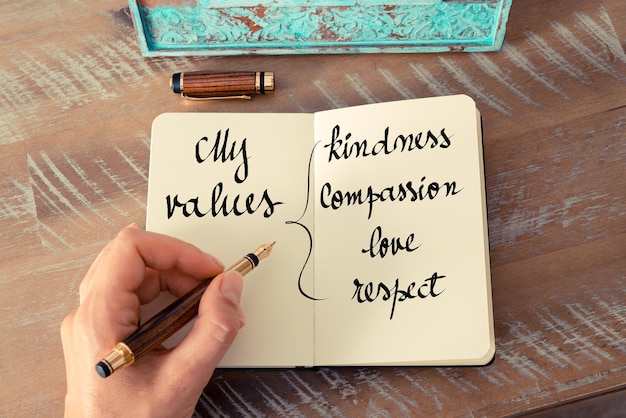 Photo midsection of person holding paper with text on table