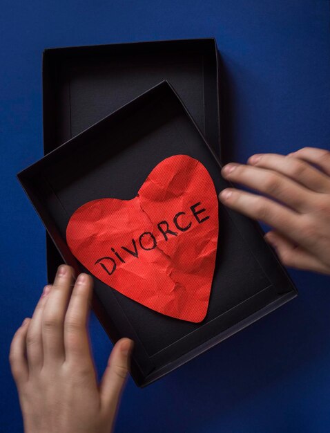 Foto sezione centrale di una persona che tiene un documento rosso sul concetto di divorzio del cuore