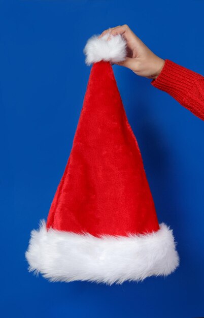 Midsection of person holding red umbrella against blue background