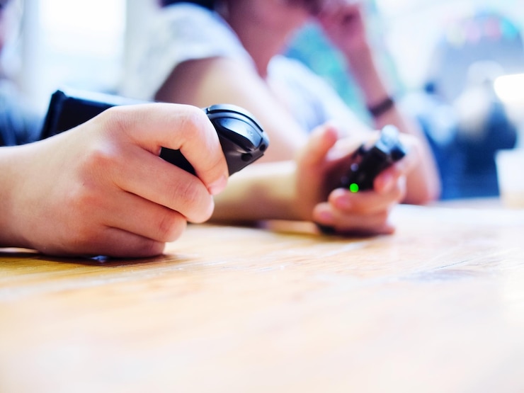Photo midsection of person holding remote control on table