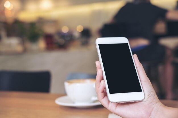 Photo midsection of person holding smart phone in cafe