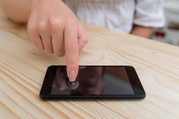 Midsection of person holding smart phone on table