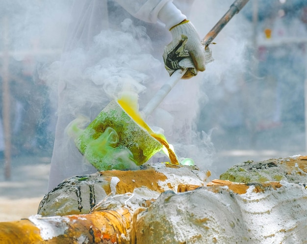 Photo midsection of person pouring hot liquid in container