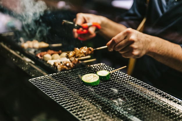 Midsection of person preparing food on barbecue grill