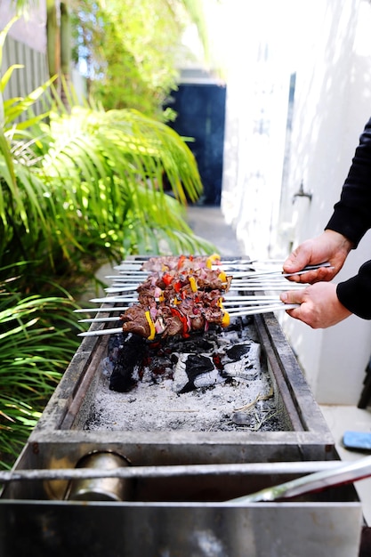 Photo midsection of person preparing food on barbecue grill