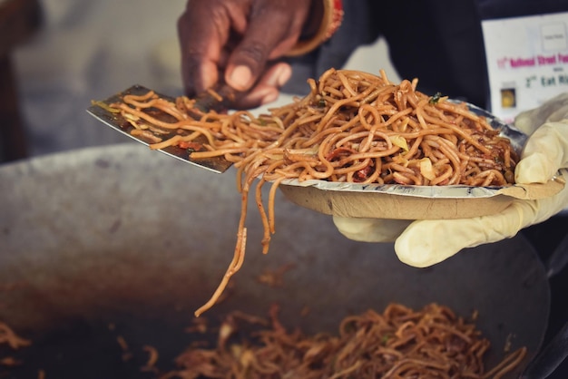 Midsection of person serving noodles