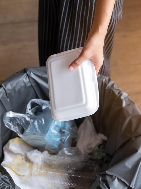 Photo midsection of person throwing garbage in can