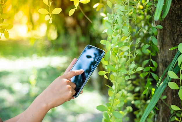 midsection of person using mobile phone outdoors