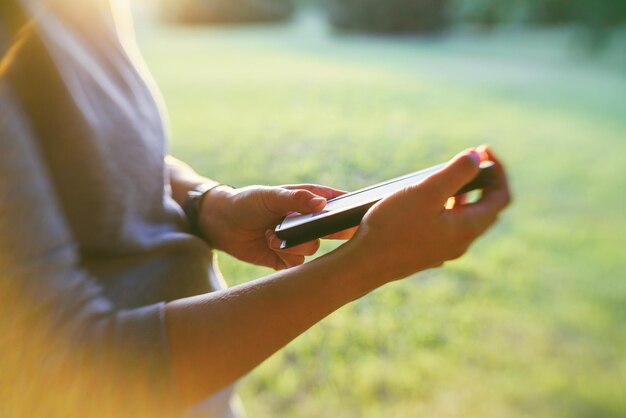 Photo midsection of person using phone on field