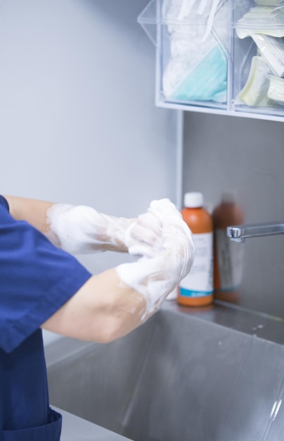 Photo midsection of person washing hands in sink