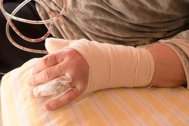 Foto sezione centrale di una persona con la mano rotta a casa