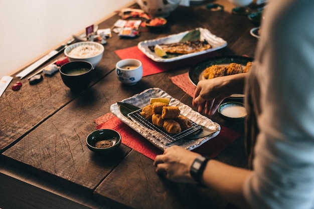テーブルの上の皿に食べ物を入れた人の中間部分