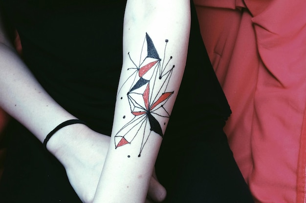 midsection of person with tattoo on hand