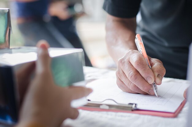 Sezione centrale di una persona che scrive su carta al tavolo