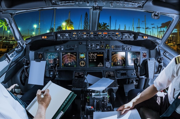 Foto sezione centrale dei piloti che tengono la carta nella cabina di pilotaggio sopra il paesaggio urbano