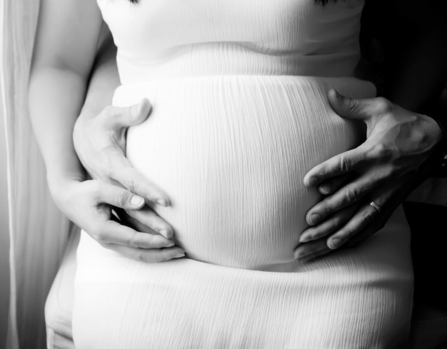 Foto sezione centrale di una donna incinta con un vestito bianco