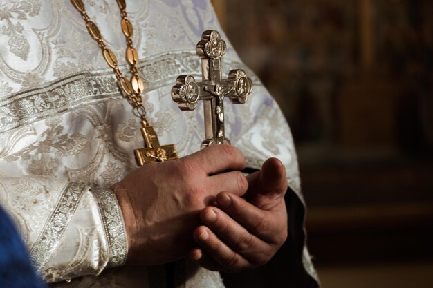 Foto sezione centrale del prete che tiene la croce in chiesa