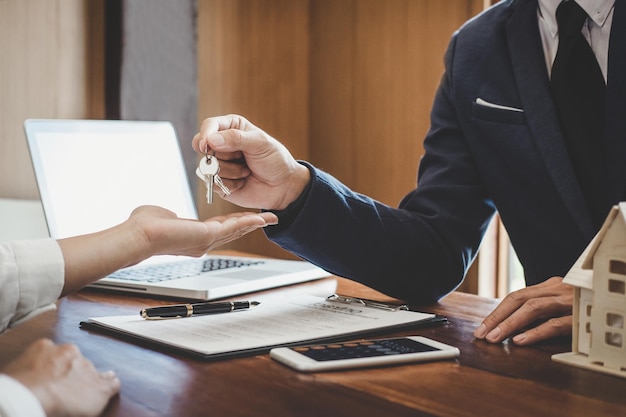 Photo midsection of real estate agent giving keys to customer