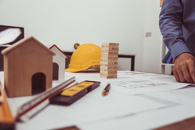 midsection of real estate agent with model house on table