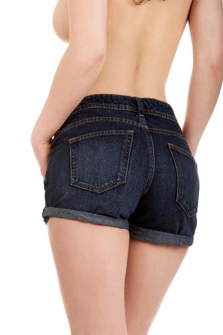 Photo 白い背景に立っているホットパンツを着たシャツなしの女性のミッドセクションの後ろの景色