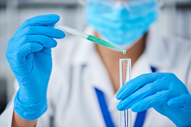 Midsection of scientist examining chemical in laboratory