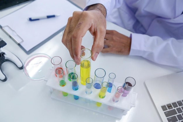 Photo midsection of scientist examining test tube at laboratory