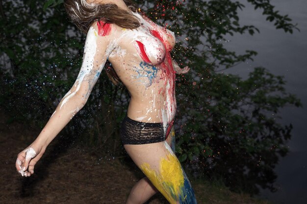 Midsection of sensuous topless woman with paint on body