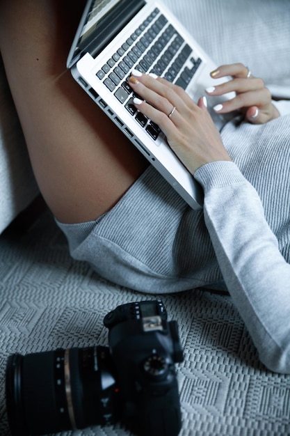 Photo midsection of sensuous woman using laptop by camera on bed